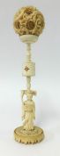 An antique carved ivory puzzle ball on carved figure stand, height 25cm with original box.