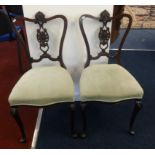 A pair of Edwardian carved mahogany bedroom chairs.