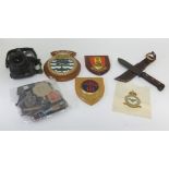 A collection of military cap badges (restrikes), cloth patches, belts, berets, folding trench spade,