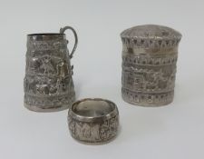 A foreign silver small tobacco jar decorated with an eastern town scene, together with a similar