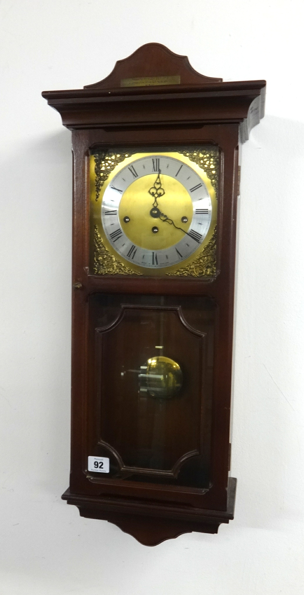 A reproduction chiming wall clock in mahogany effect case.