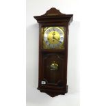 A reproduction chiming wall clock in mahogany effect case.