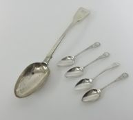 A large silver serving spoon and four teaspoons.