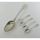 A large silver serving spoon and four teaspoons.