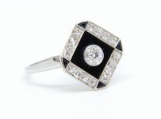 A ladies platinum and diamond black onyx square dress ring comprising a single old cut diamond