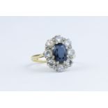 An 18ct sapphire and diamond cluster ring, size L/M.
