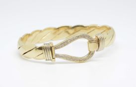 A 9ct gold and diamond set bangle, approx 52gms.