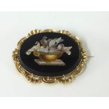 An antique gold and micro mosaic brooch depicting birds on a bird bath.