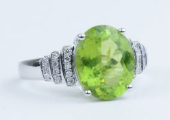 A 14k white gold and diamond ring set with an oval cut peridot approx 3.56ct, diamonds approx 0.25ct