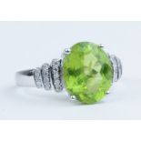 A 14k white gold and diamond ring set with an oval cut peridot approx 3.56ct, diamonds approx 0.25ct
