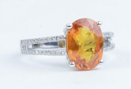 A 14k white gold and diamond ring set with an oval cut yellow sapphire approx 4.20ct, diamonds