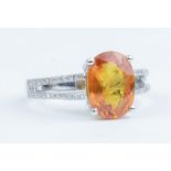 A 14k white gold and diamond ring set with an oval cut yellow sapphire approx 4.20ct, diamonds