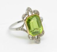 An antique peridot and diamond ring set in platinum and yellow gold, the octagonal old cut peridot