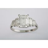 A fine five stone diamond and platinum ring, comprising a very good emerald cut centre stone of high