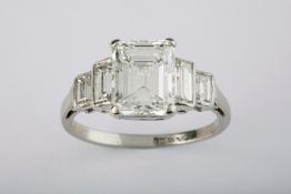 A fine five stone diamond and platinum ring, comprising a very good emerald cut centre stone of high