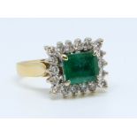 An 18ct emerald and diamond cluster ring, size L.