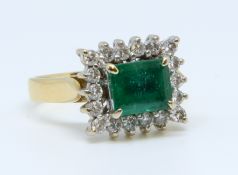 An 18ct emerald and diamond cluster ring, size L.