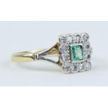 An 18ct emerald and diamond square set ring, size M.