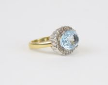 An 18ct aqua marine and diamond cluster ring set with an oval cut stone, size M.