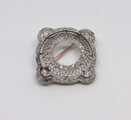 An antique platinum hand crafted designer brooch consisting of a inner circle with a filigree border