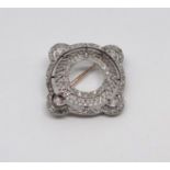 An antique platinum hand crafted designer brooch consisting of a inner circle with a filigree border