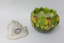 A pottery jardinière decorated with flowers together with a conch shell cameo carved with three