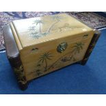 An Oriental carved camphorwood blanket chest decorated with tiger and palm trees together with a set