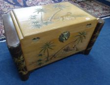 An Oriental carved camphorwood blanket chest decorated with tiger and palm trees together with a set