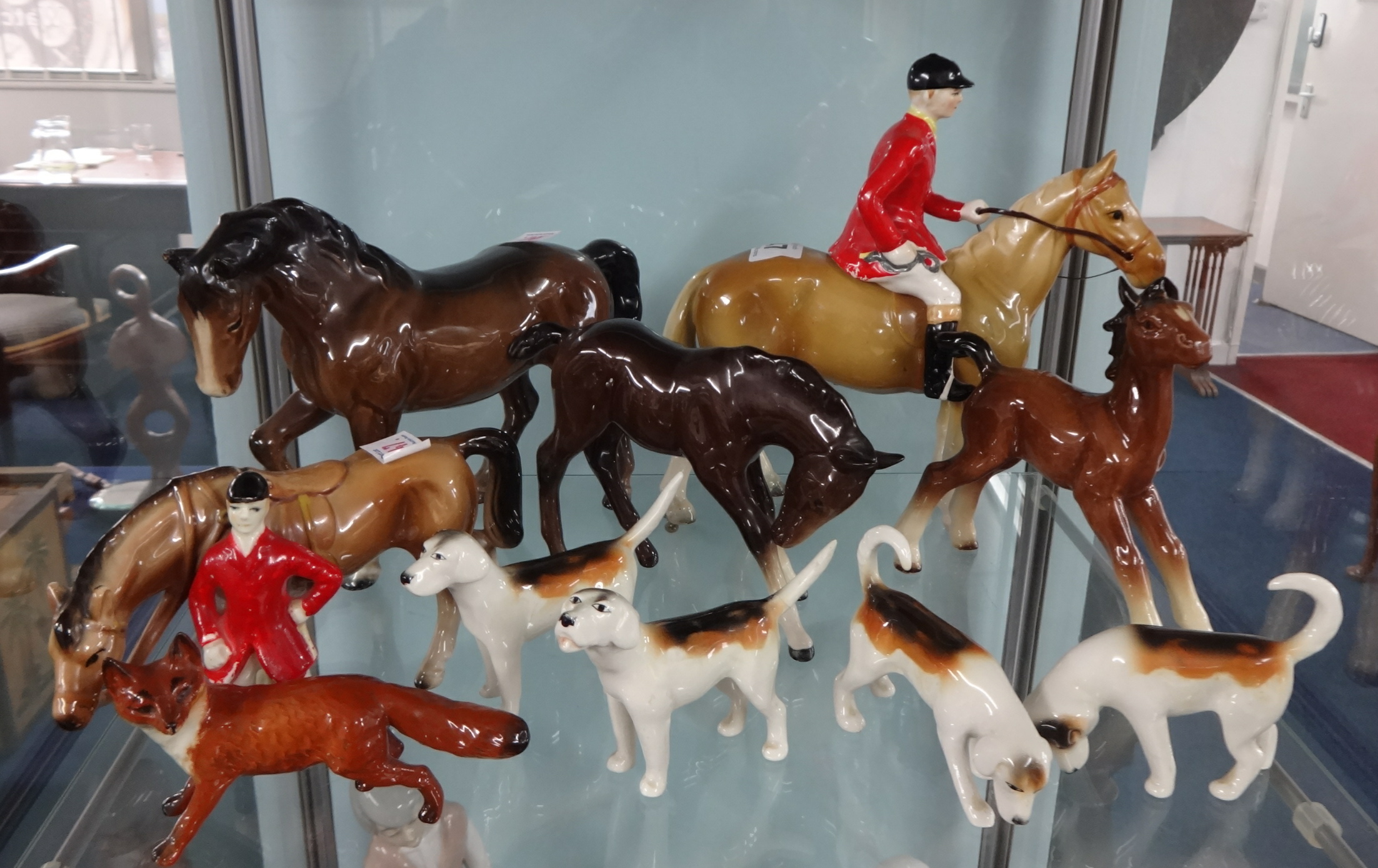 A Beswick horse, foal, fox and four hounds together with two Beswick type hunt horses and a single