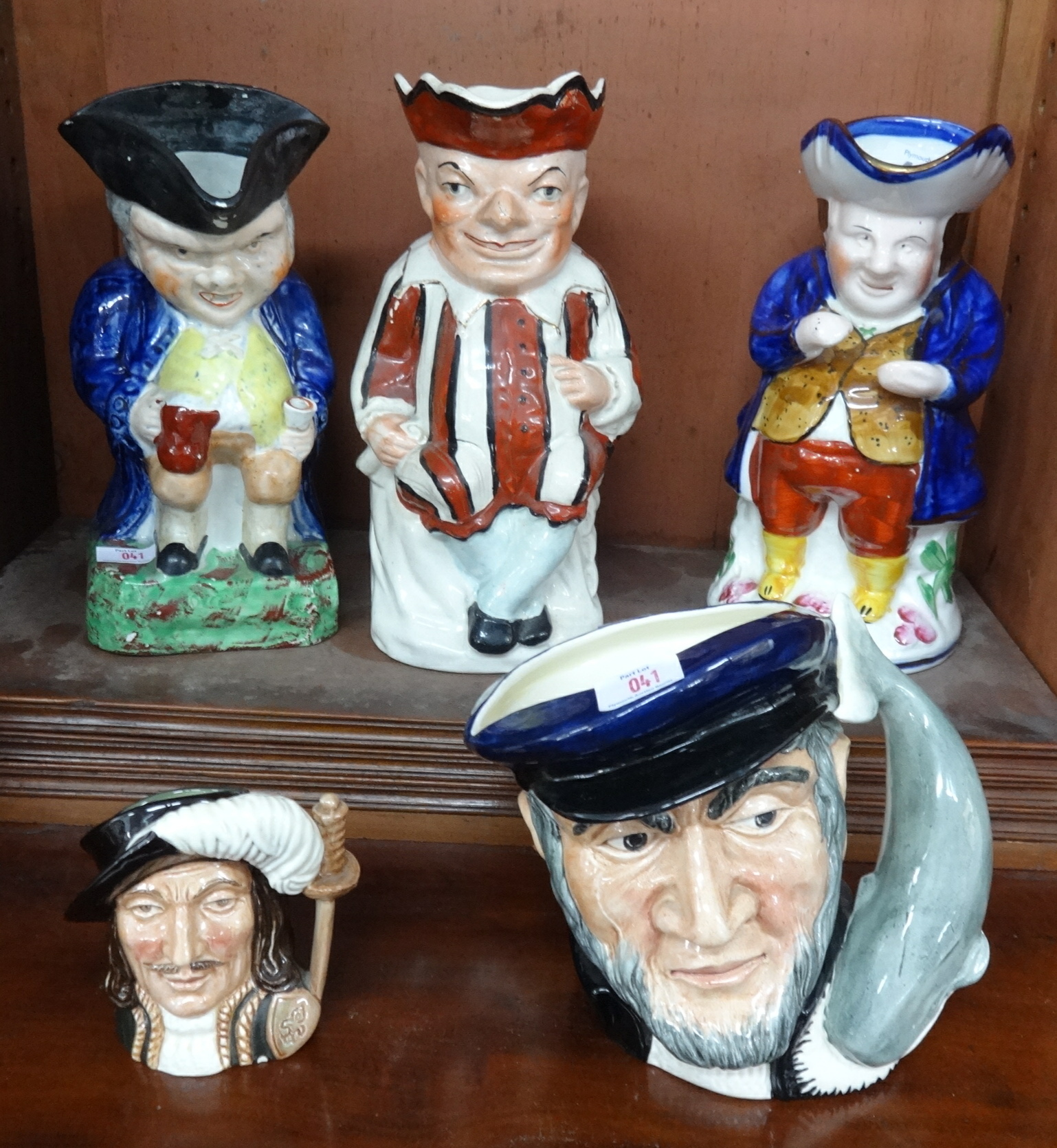 A 19th century Toby jug, a pottery punch Toby jug, three others including Royal Doulton Captain Ahab