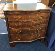 A mahogany serpentine four drawer bachelors chest with brushing slide of Georgian style, width