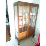 An oak display cabinet and a mahogany bow low chest of drawers (2).