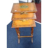 An Edwardian satinwood nest of three tables, the tops each painted with musical instruments on