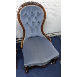 A Victorian walnut framed nursing chair with button back upholstery.