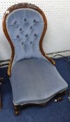 A Victorian walnut framed nursing chair with button back upholstery.