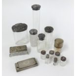 A collection of silver topped toilet jars and a silver rectangular match striker.