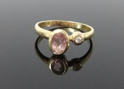 A yellow metal dress ring set with a single diamond and another coloured stone, size K.