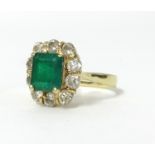 An 18ct emerald and diamond cluster ring, marked '18k', size Q.
