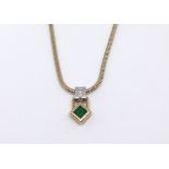 An emerald and diamond pendant necklace.