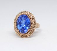 A high carat yellow gold dress ring set with a blue gemstone, size M.