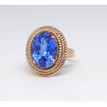A high carat yellow gold dress ring set with a blue gemstone, size M.