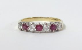 An 18ct ruby and diamond seven stone ring, size O.
