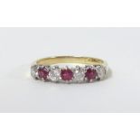 An 18ct ruby and diamond seven stone ring, size O.