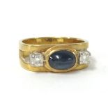 A poulson cabochon sapphire and diamond three stone ring, size K.