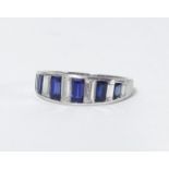 A sapphire and diamond ring set in white gold or platinum, channel set with 13 baguette cut