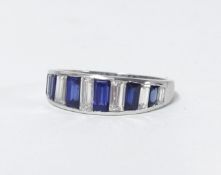 A sapphire and diamond ring set in white gold or platinum, channel set with 13 baguette cut