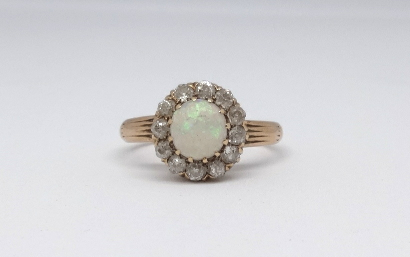 An 18ct opal and diamond cluster ring, size N.