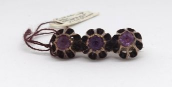 A Victorian 14k three stone amethyst brooch.