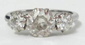 A platinum three stone diamond ring set with round brilliant cut diamonds, the centre diamond approx