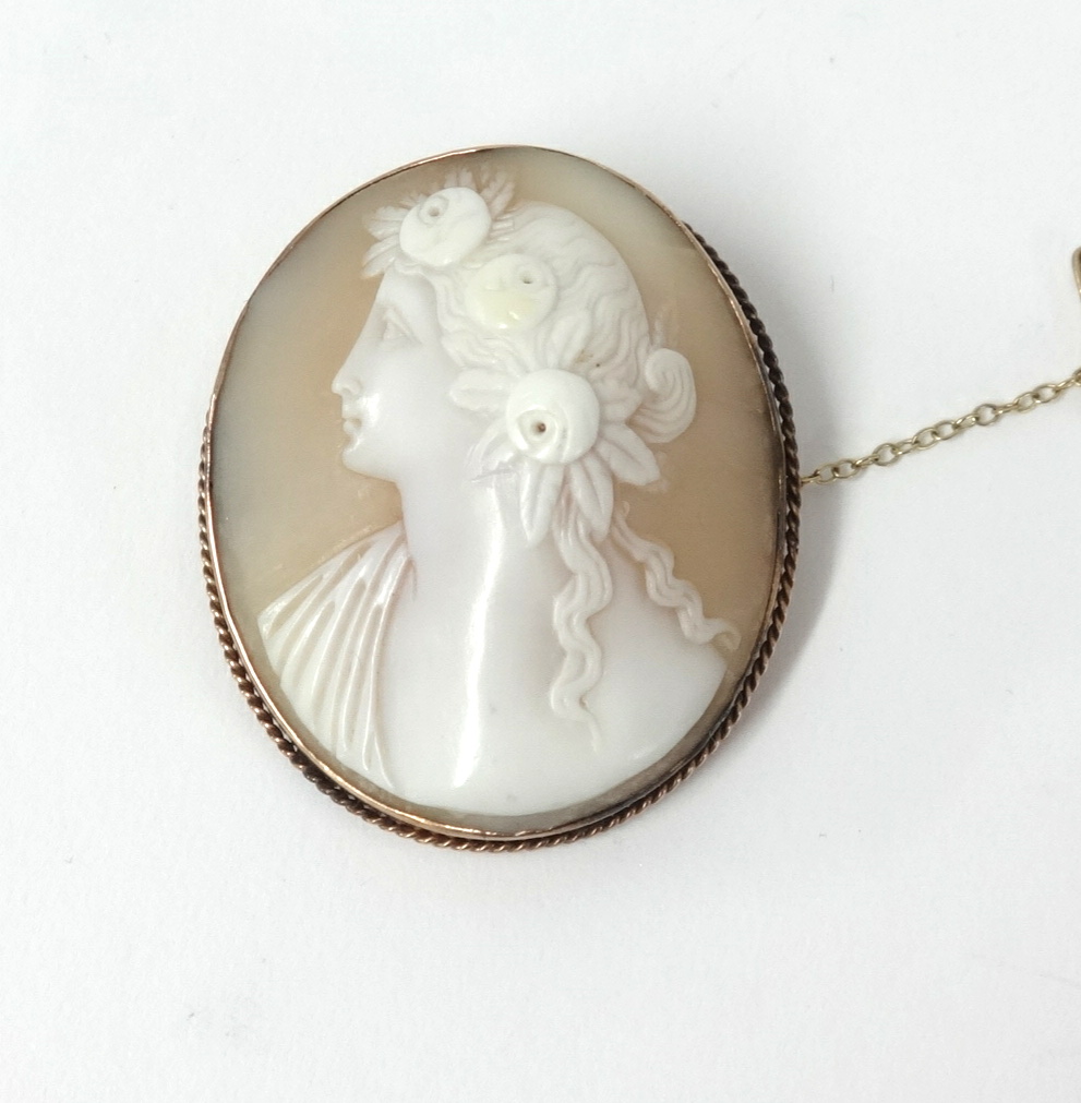 A yellow metal set cameo brooch with a portrait of a lady.